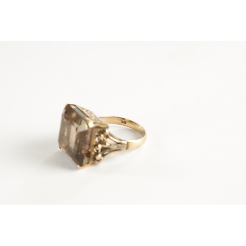 319 - A LARGE 9CT GOLD SMOKEY QUARTZ RING The square cut stone mounted in a pierced claw setting, total we... 