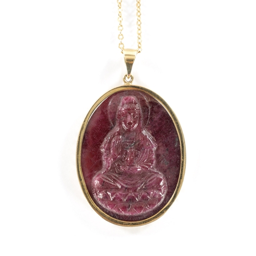 339 - A 9CT GOLD CARVED RUBY PENDENT Depicting a Buddha within a gold oval frame with loop suspension and ... 