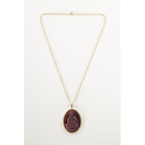 339 - A 9CT GOLD CARVED RUBY PENDENT Depicting a Buddha within a gold oval frame with loop suspension and ... 