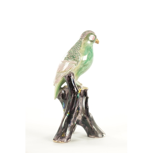 35 - A 19TH CENTURY CERAMIC PERCHED PARROT FIGURE the well modelled green glazed bird on a majolica type ... 