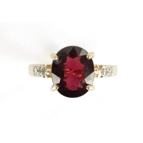 366 - A 9CT GOLD RUBELLITE AND DIAMOND RING The large stone in a four claw setting with diamond shoulders,... 