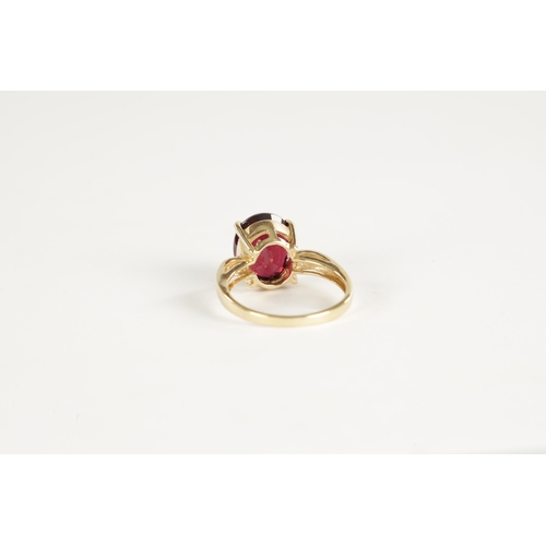 366 - A 9CT GOLD RUBELLITE AND DIAMOND RING The large stone in a four claw setting with diamond shoulders,... 