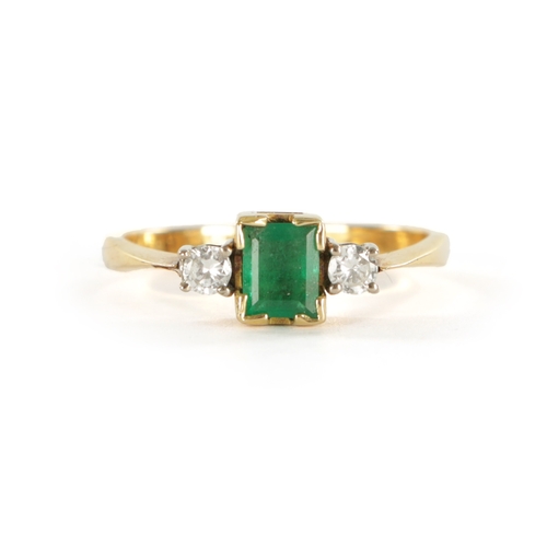 384 - AN 18CT GOLD EMERALD AND DIAMOND RING with rectangular cut emerald flanked by two brilliant cut diam... 