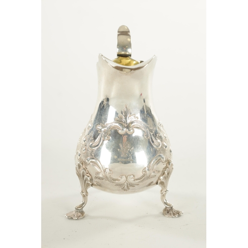 395 - A VICTORIAN SILVER CREAM JUG the bulbous squat body embossed with floral sprays; standing on c scrol... 