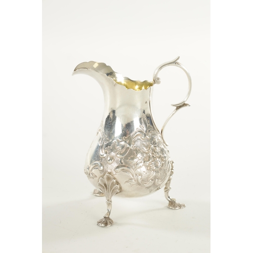 395 - A VICTORIAN SILVER CREAM JUG the bulbous squat body embossed with floral sprays; standing on c scrol... 
