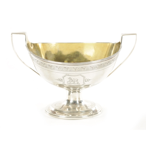 396 - A GEORGE III SILVER SUGAR BASKET with arcaded border, armorial panels and reeded decoration; raised ... 