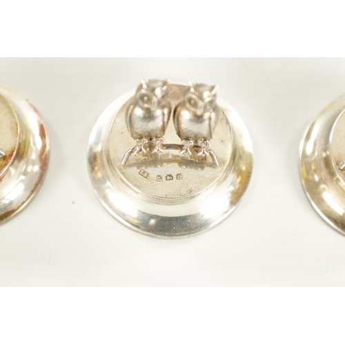 432 - AN UNUSUAL CASED SET OF FOUR GEORGE V SILVER DOUBLE OWL MENU HOLDERS of circular pedestal form with ... 