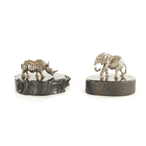 438 - TWO PATRICK MAVROSS MINIATURE SILVER SCULPTURES formed as a Rhinoceros and an Elephant having white ... 