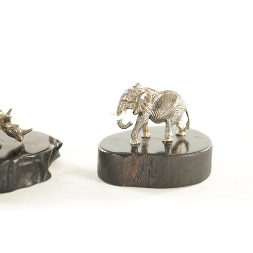 438 - TWO PATRICK MAVROSS MINIATURE SILVER SCULPTURES formed as a Rhinoceros and an Elephant having white ... 