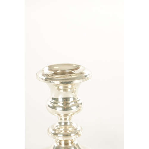 445 - A PAIR OF FILLED SILVER CANDLESTICKS BY GORHAM of squat ringed form with moulded circular bases (12c... 