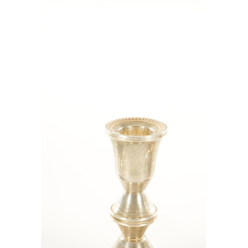 454 - A PAIR OF STERLING SILVER SHORT CIRCULAR BASE CANDLESTICKS with feathered borders and knopped stems ... 