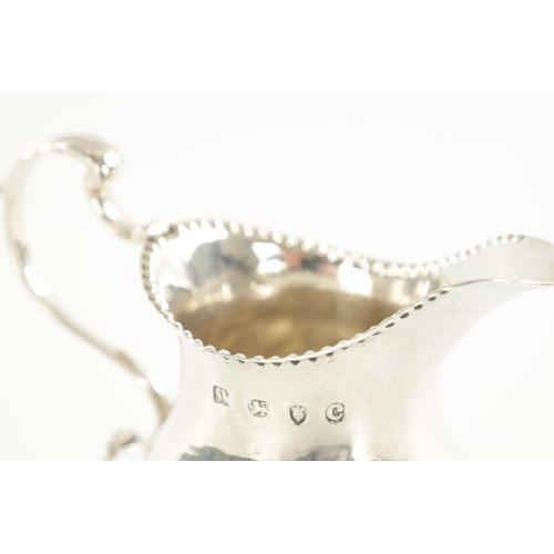 458 - A GEORGE III SILVER FOOTED CREAM JUG bulbous body with beaded rims and scrolling handle, London, 181... 