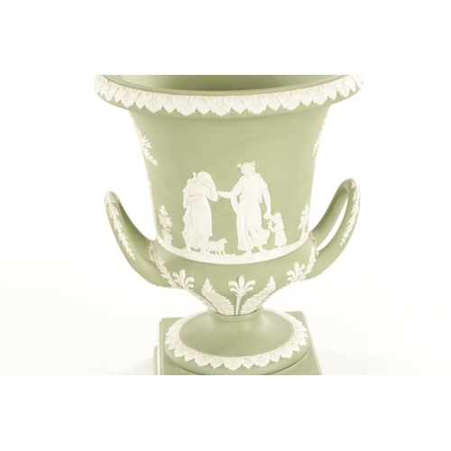 65 - A WEDGWOOD GREEN JASPER WARE TWO-HANDLED URN SHAPED VASE AND COVER ON PEDESTAL BASE decorated with a... 