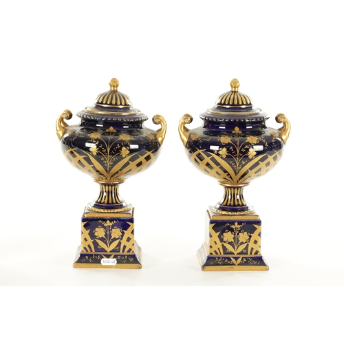 70 - A PAIR OF LATE 19TH CENTURY ROYAL BLUE AND GILT VIENNA STYLE LIDDED VASES the two-handled urn-shaped... 