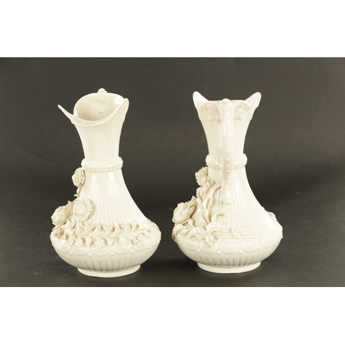 87 - A GOOD PAIR OF 19TH CENTURY BELLEEK, CO. FERMANAGH BLANC DI CHINE PORCELAIN EWERS the elegant ribbed... 