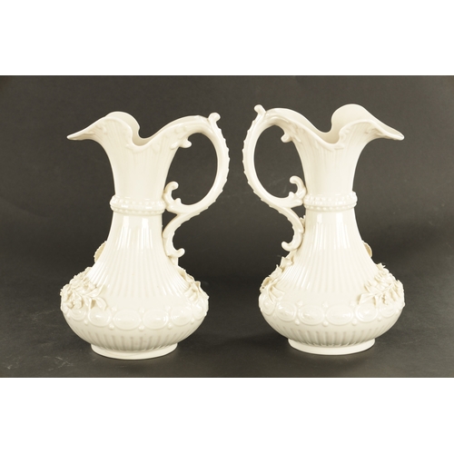 87 - A GOOD PAIR OF 19TH CENTURY BELLEEK, CO. FERMANAGH BLANC DI CHINE PORCELAIN EWERS the elegant ribbed... 