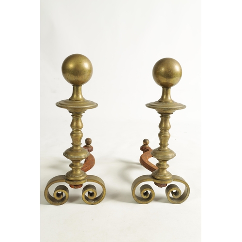 741 - A PAIR OF EARLY 19TH CENTURY TURNED BRASS FIRE DOGS with spherical ball finials on scrolled feet (45... 