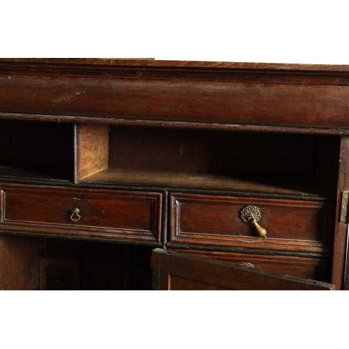 1414 - AN EARLY 18TH CENTURY OAK GEOMETRIC MOULDED CABINET ON STAND with cushion moulded cornice above a pa... 