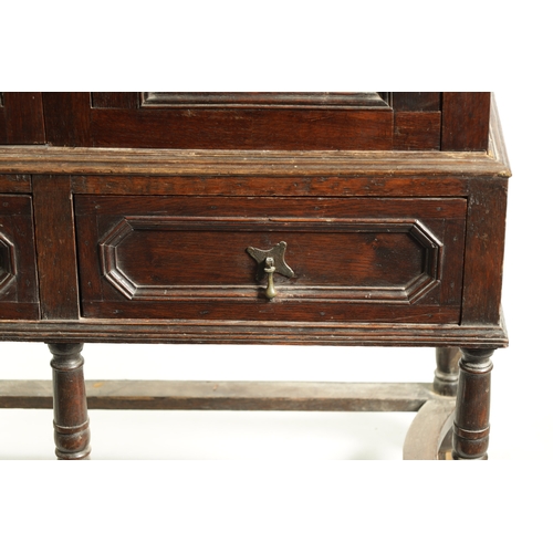 1414 - AN EARLY 18TH CENTURY OAK GEOMETRIC MOULDED CABINET ON STAND with cushion moulded cornice above a pa... 