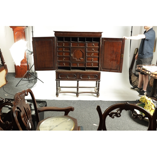 1414 - AN EARLY 18TH CENTURY OAK GEOMETRIC MOULDED CABINET ON STAND with cushion moulded cornice above a pa... 