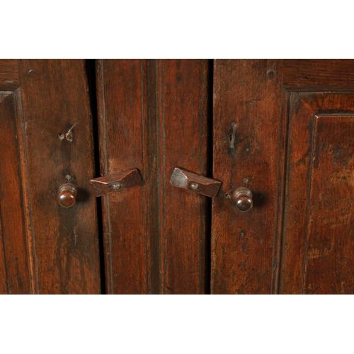 1424 - AN EARLY 18TH CENTURY OAK POSTED CANOPY DRESSER with shaped overhanging moulded top supported by rin... 