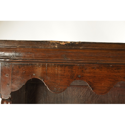 1424 - AN EARLY 18TH CENTURY OAK POSTED CANOPY DRESSER with shaped overhanging moulded top supported by rin... 