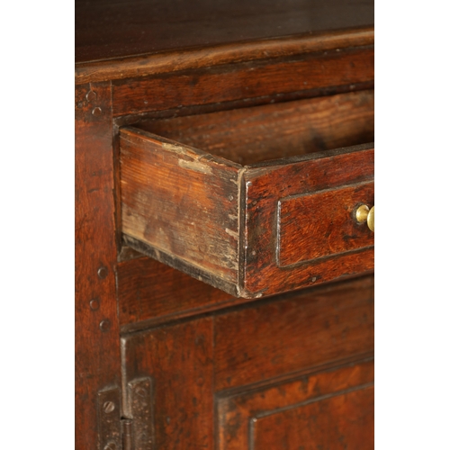 1424 - AN EARLY 18TH CENTURY OAK POSTED CANOPY DRESSER with shaped overhanging moulded top supported by rin... 