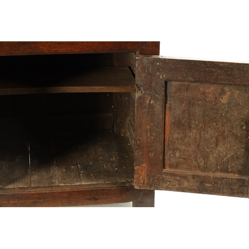 1424 - AN EARLY 18TH CENTURY OAK POSTED CANOPY DRESSER with shaped overhanging moulded top supported by rin... 