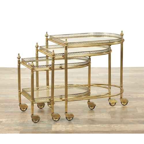 1427 - MAISON BAGUES BELGIUM A 20TH CENTURY GILT BRASS AND GLASS NEST OF THREE TABLES of bowed form on cast... 