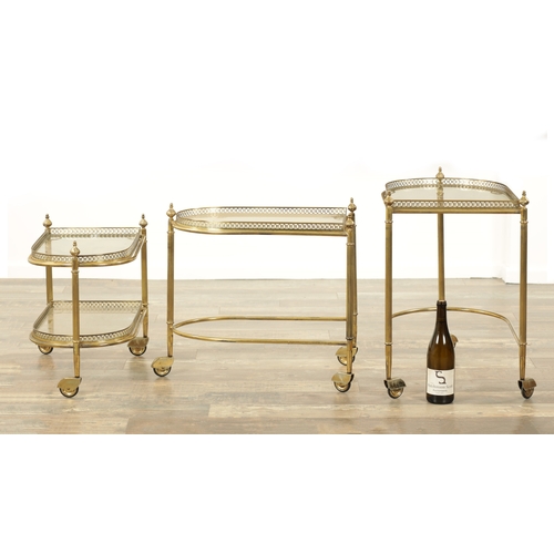 1427 - MAISON BAGUES BELGIUM A 20TH CENTURY GILT BRASS AND GLASS NEST OF THREE TABLES of bowed form on cast... 