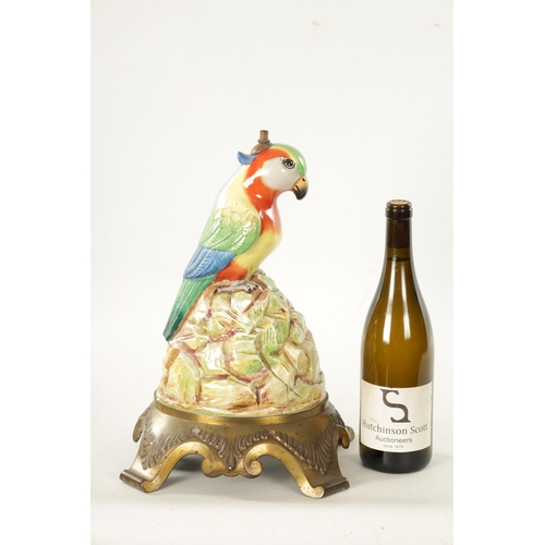 49 - AN EARLY 20TH CENTURY PORCELAIN AND CAST BRASS TABLE LAMP FORMED AS A PARROT the colourful perched b... 