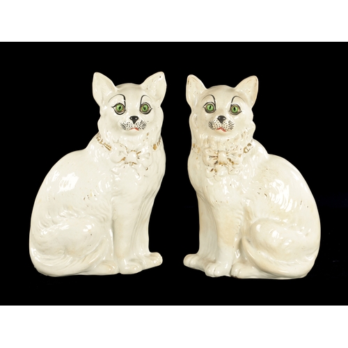 162 - A PAIR OF LATE 19TH CENTURY SCOTTISH POTTERY CATS with glass eyes and gilt collars. (31cm high )