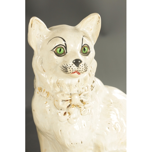 162 - A PAIR OF LATE 19TH CENTURY SCOTTISH POTTERY CATS with glass eyes and gilt collars. (31cm high )