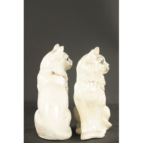 162 - A PAIR OF LATE 19TH CENTURY SCOTTISH POTTERY CATS with glass eyes and gilt collars. (31cm high )