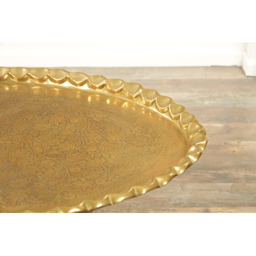 413 - A LARGE 20TH CENTURY EASTERN LARGE OVAL TRAY TOP COFFEE TABLE with embossed leaf work decoration on ... 