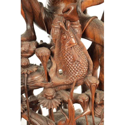 416 - A 19TH CENTURY CHINESE HARDWOOD CARVED FIGURAL SCULPTURE of a fisherman or a flowering foliated base... 