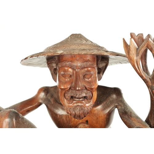 416 - A 19TH CENTURY CHINESE HARDWOOD CARVED FIGURAL SCULPTURE of a fisherman or a flowering foliated base... 