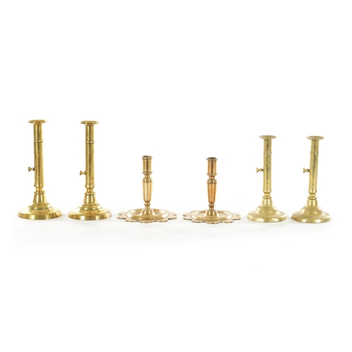 540 - TWO PAIRS OF GEORGE III CIRCULAR BASE BRASS CANDLESTICKS with ejector stems TOGETHER WITH A SHORT PA... 