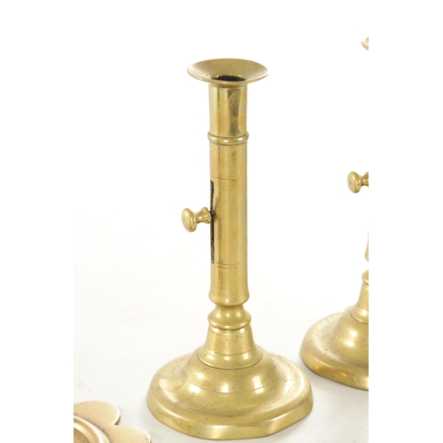 540 - TWO PAIRS OF GEORGE III CIRCULAR BASE BRASS CANDLESTICKS with ejector stems TOGETHER WITH A SHORT PA... 