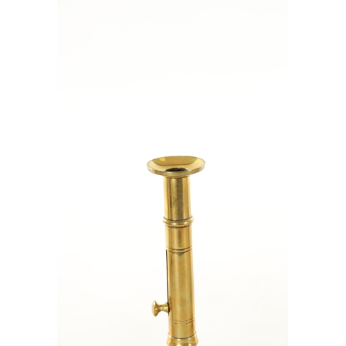 540 - TWO PAIRS OF GEORGE III CIRCULAR BASE BRASS CANDLESTICKS with ejector stems TOGETHER WITH A SHORT PA... 