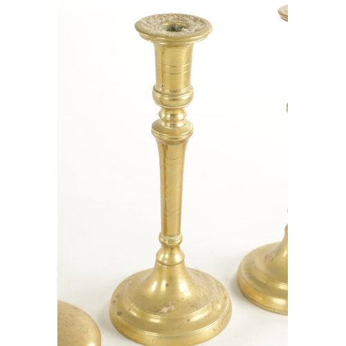 541 - THREE PAIRS OF 18TH CENTURY BRASS PETAL BASE AND EJECTOR STEM CANDLESTICKS and a later pair (petal b... 