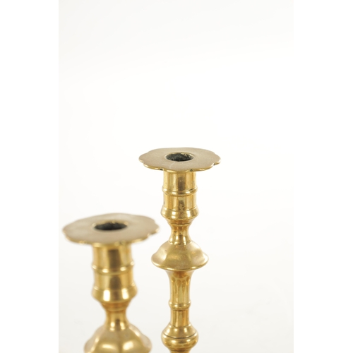 555 - A COLLECTION OF FOUR PAIRS OF EARLY 18TH CENTURY BRASS CANDLESTICKS including a pair with side eject... 