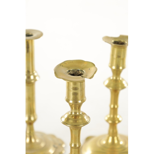 555 - A COLLECTION OF FOUR PAIRS OF EARLY 18TH CENTURY BRASS CANDLESTICKS including a pair with side eject... 