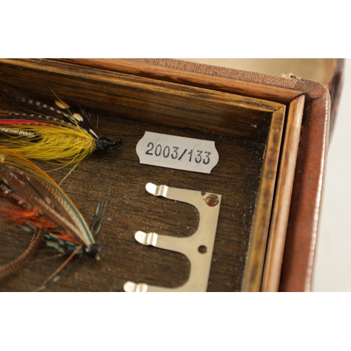 587 - A VINTAGE LEATHER FISHING TACKLE BOX WITH VARIOUS SALMON FLIES having a hinged lid with brass lock, ... 