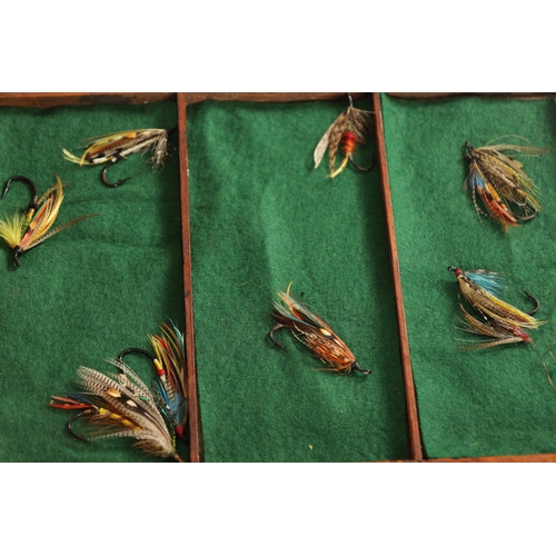 631 - A VINTAGE FISHING TACKLE BOX WITH VARIOUS SALMON FLIES AND LURES having graduated drawers and a hing... 