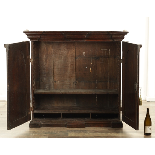 827 - AN EARLY 18TH CENTURY ARCHITECTURAL OAK BOOKCASE the deep moulded cornice above a pair of raised fie... 