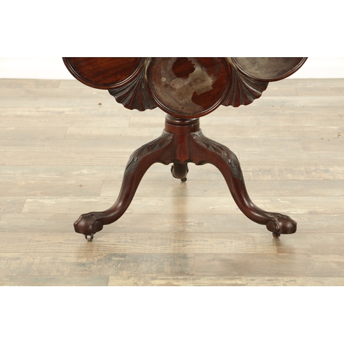 830 - A GEORGE III MAHOGANY TILT TOP TABLE with shell and leaf carved dished top above a turned stem with ... 