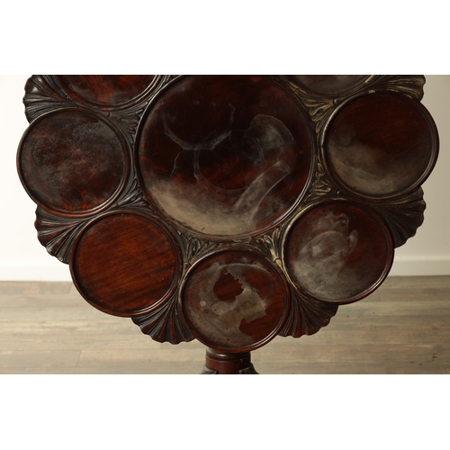 830 - A GEORGE III MAHOGANY TILT TOP TABLE with shell and leaf carved dished top above a turned stem with ... 