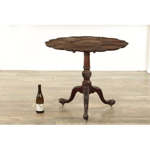 830 - A GEORGE III MAHOGANY TILT TOP TABLE with shell and leaf carved dished top above a turned stem with ... 