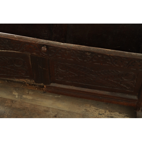 831 - A 17TH CENTURY WESTMORLAND JOINED OAK CRADLE with leaf carved panelled body and raised turned uprigh... 